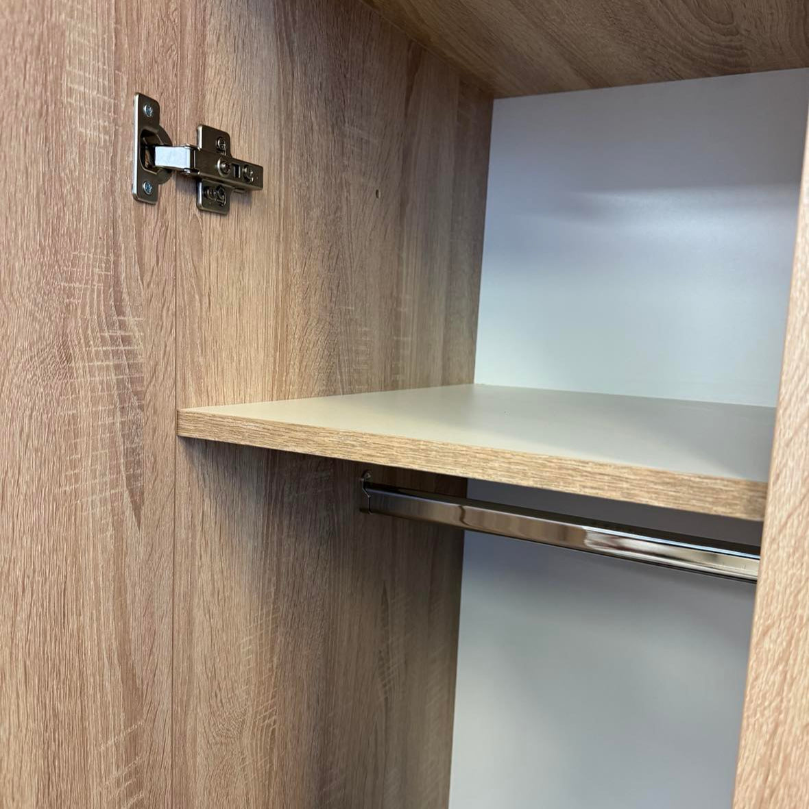 inside of our contract grade wardrobe. Picture shows hanging space and shelving. High quality soft close hinges on the wardrobe doors.