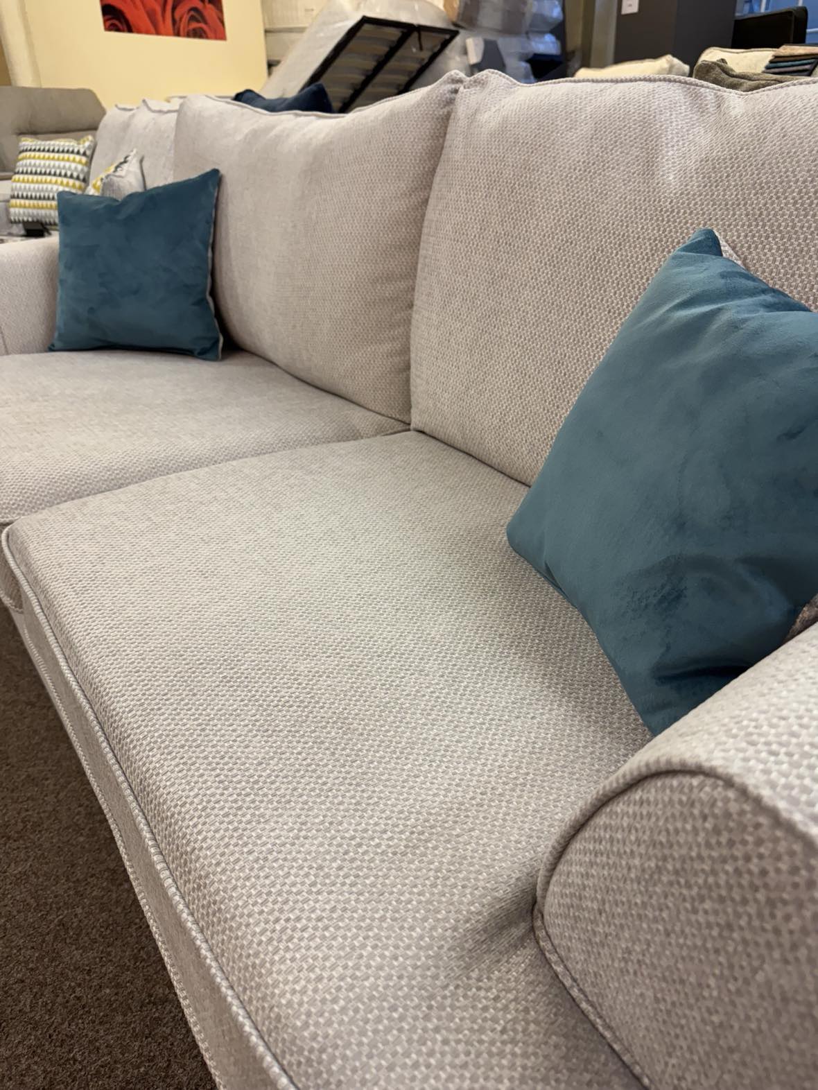 close up of Jessie Sofa by ScS Living showing pebble grey material used to upholster cushions and solid wood frame. Scatter cushions also included for Free. Visit our sofa outlet shop in Lancaster, Lancashire now!