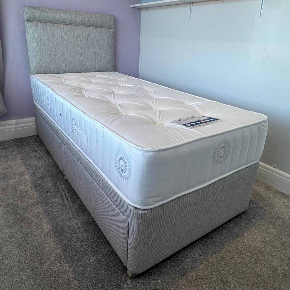 the Lancaster Ortho divan bed, mattress and headboard set by Sweet Dreams UK. Pictured with 2 drawers for storage in a Biscotti coloured fabric. On Casters for easy movement.